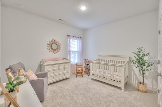 bedroom with a nursery area and light colored carpet