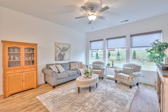 living room featuring ceiling fan and light hardwood / wood-style floors