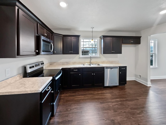 kitchen with sink, decorative light fixtures, dark hardwood / wood-style floors, and appliances with stainless steel finishes