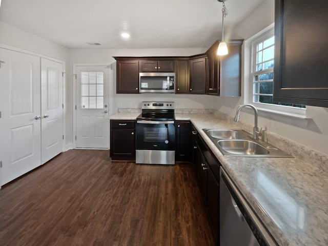 kitchen with decorative light fixtures, sink, dark hardwood / wood-style flooring, stainless steel appliances, and dark brown cabinets