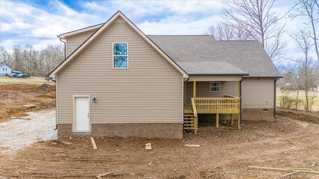 rear view of house featuring a shingled roof