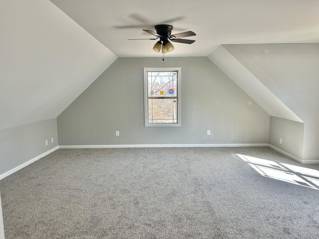 additional living space with carpet flooring, ceiling fan, baseboards, and vaulted ceiling