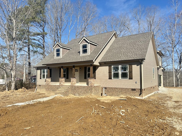 new england style home featuring crawl space, roof with shingles, and covered porch