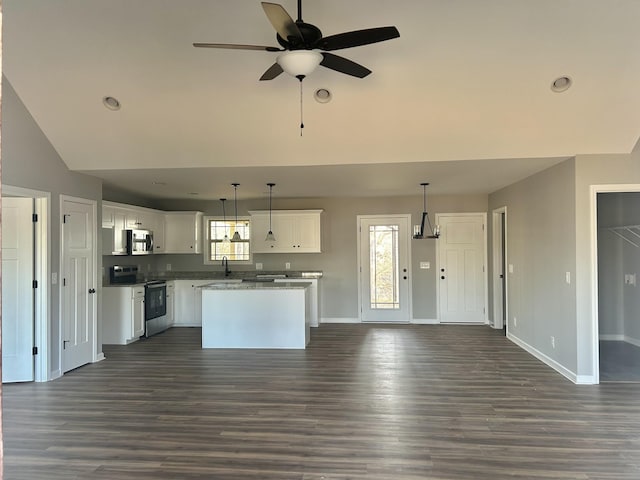 kitchen featuring dark wood-type flooring, open floor plan, a center island, white cabinetry, and appliances with stainless steel finishes