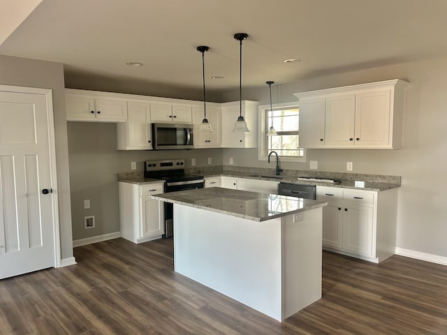 kitchen featuring white cabinetry, light stone countertops, appliances with stainless steel finishes, and a sink