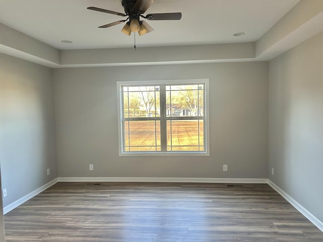 empty room with baseboards, wood finished floors, and a ceiling fan