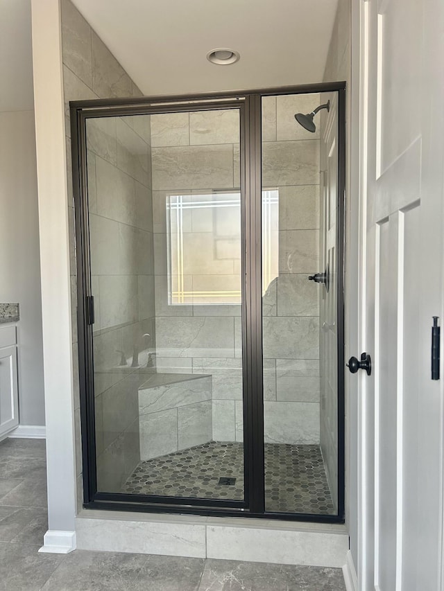 bathroom featuring a shower stall and baseboards