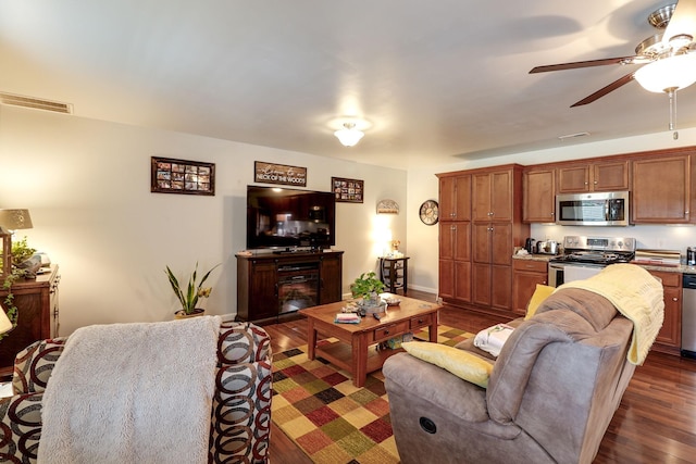 living room with ceiling fan and dark hardwood / wood-style flooring