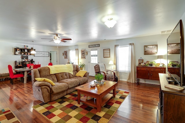 living room with dark hardwood / wood-style flooring and ceiling fan