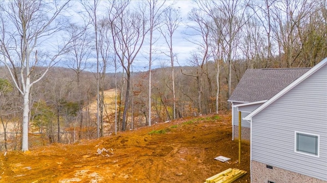 view of yard featuring a forest view