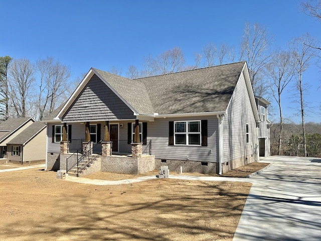 view of front of house featuring crawl space, roof with shingles, and a porch