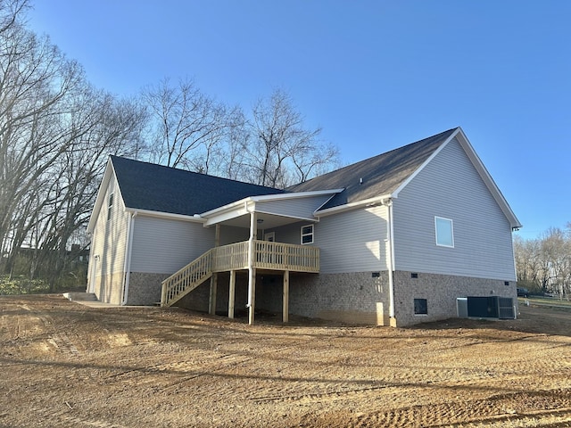 rear view of property featuring central air condition unit and stairway