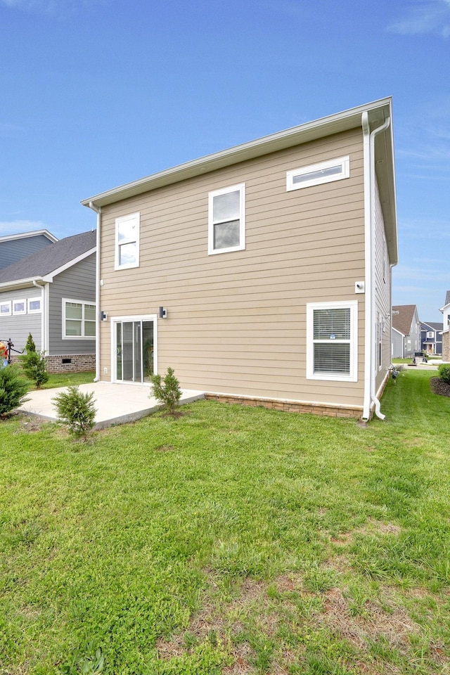 back of property featuring a patio and a lawn