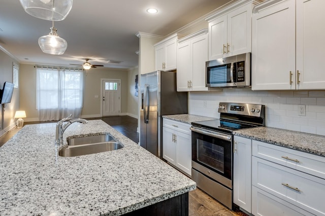 kitchen with stainless steel appliances, hanging light fixtures, sink, and white cabinets