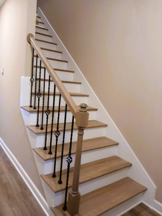 stairs featuring hardwood / wood-style flooring