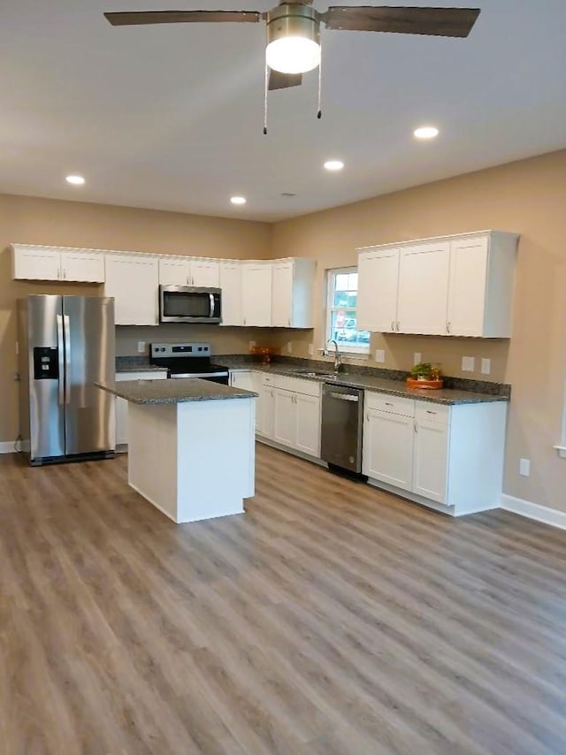 kitchen featuring white cabinetry, appliances with stainless steel finishes, a kitchen island, and light hardwood / wood-style flooring