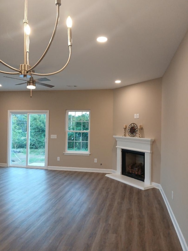 unfurnished living room featuring ceiling fan, dark hardwood / wood-style floors, and a wealth of natural light