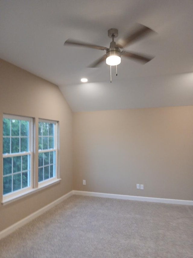 carpeted spare room with lofted ceiling and ceiling fan