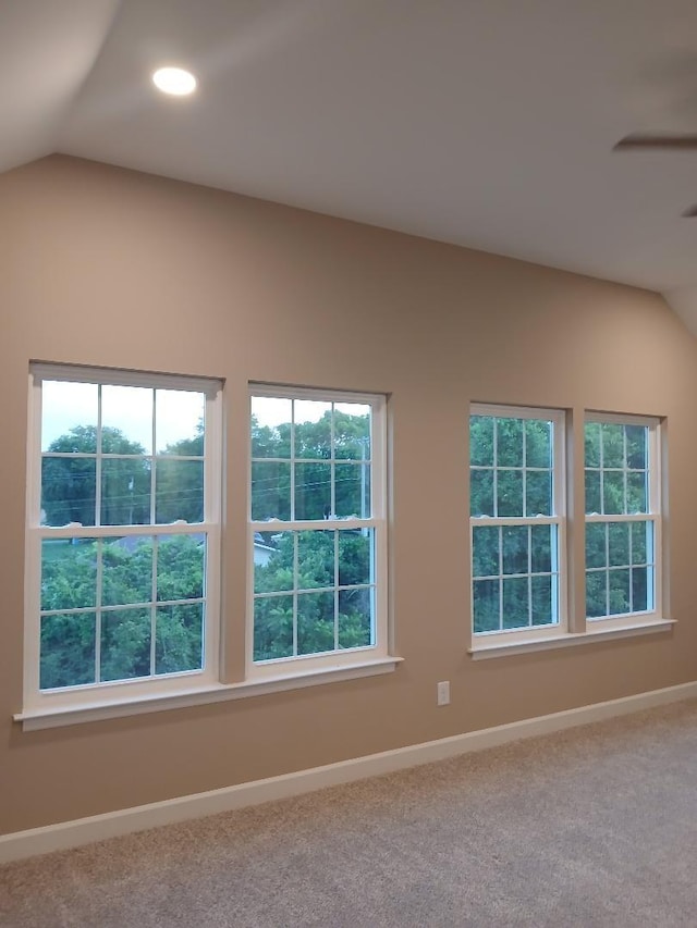 carpeted spare room with lofted ceiling and plenty of natural light