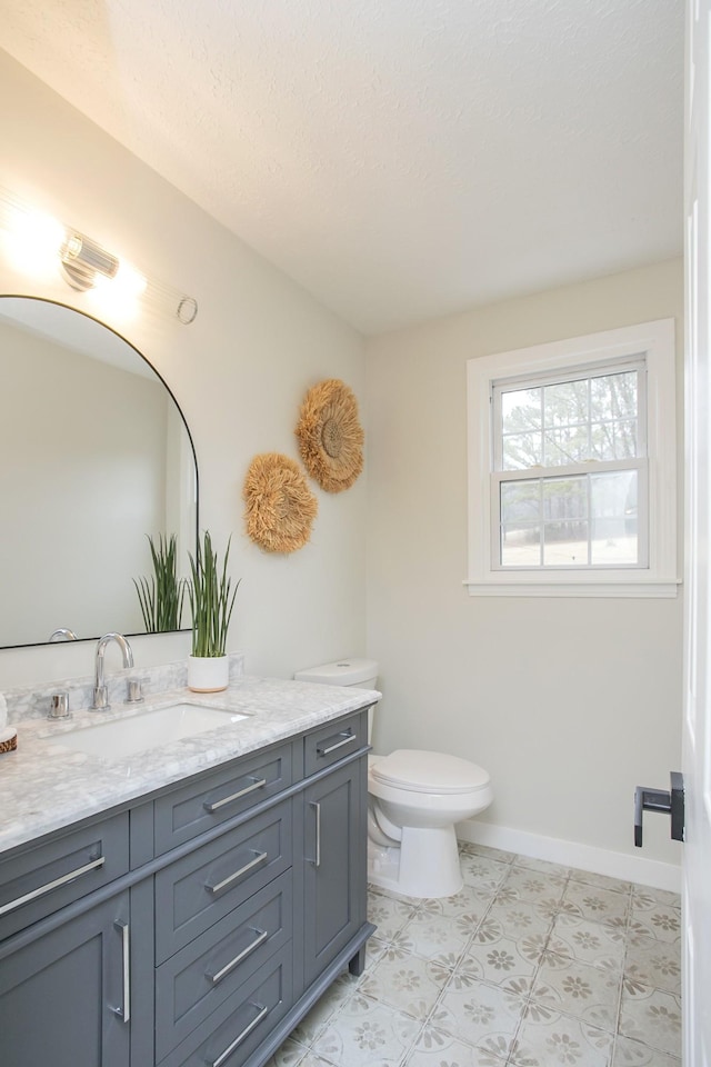 bathroom with vanity, a textured ceiling, and toilet