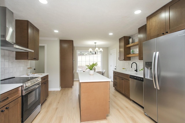 kitchen with sink, a center island, pendant lighting, stainless steel appliances, and wall chimney range hood