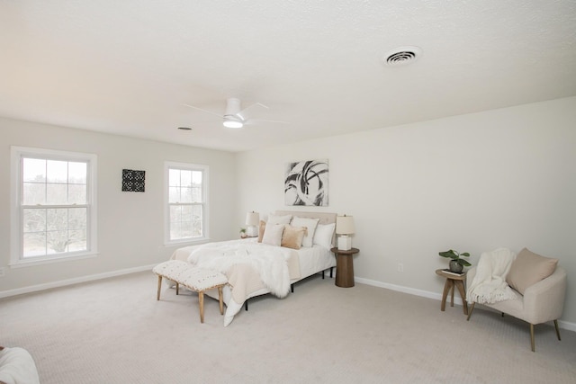 carpeted bedroom with ceiling fan and a textured ceiling