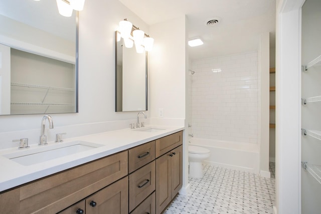 full bathroom featuring vanity, tiled shower / bath combo, and toilet