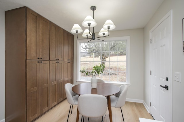 dining space featuring an inviting chandelier and light wood-type flooring