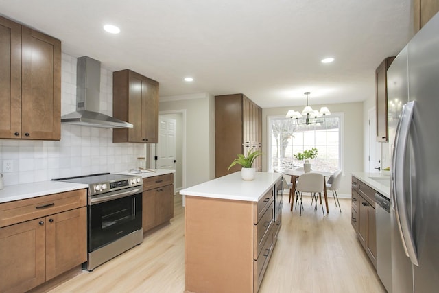 kitchen with tasteful backsplash, a center island, light hardwood / wood-style flooring, appliances with stainless steel finishes, and wall chimney range hood