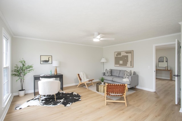 living room with crown molding, ceiling fan, and light hardwood / wood-style floors