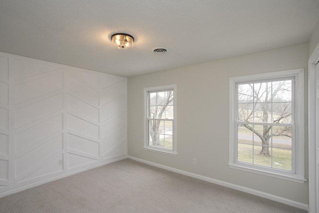 carpeted spare room featuring a textured ceiling