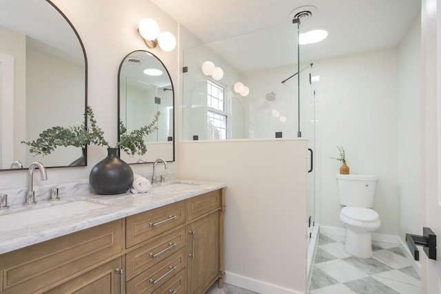 bathroom with vanity, toilet, and a shower with shower door