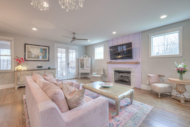 living room with a healthy amount of sunlight, light hardwood / wood-style floors, and french doors