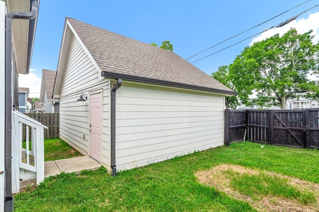 view of property exterior with an outdoor structure and a lawn