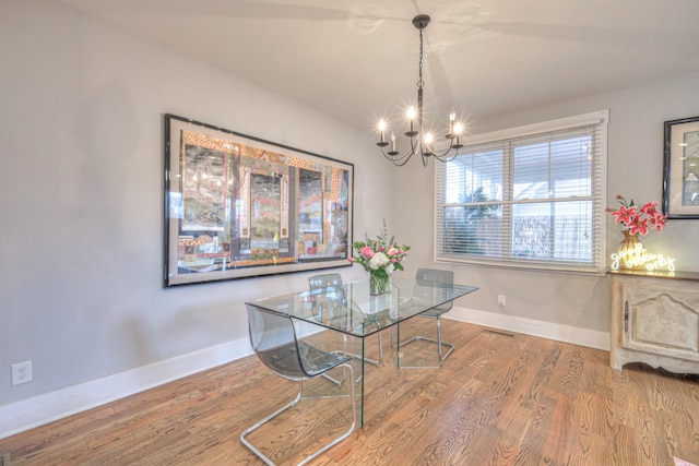 dining room with wood-type flooring and a chandelier