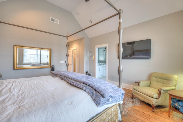 bedroom with lofted ceiling, hardwood / wood-style floors, and ensuite bathroom