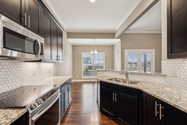 kitchen featuring sink, light stone counters, crown molding, appliances with stainless steel finishes, and pendant lighting