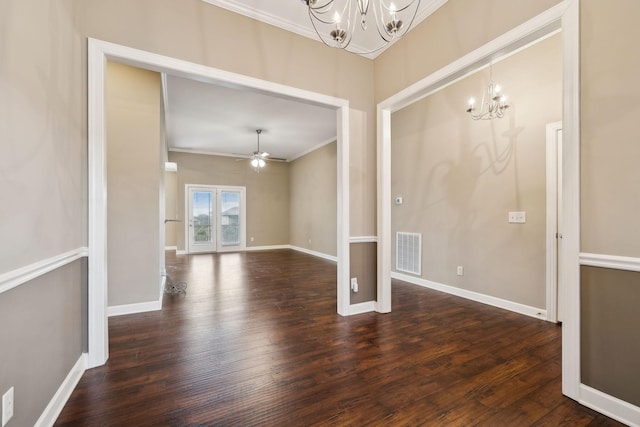 empty room with ornamental molding, dark hardwood / wood-style floors, and ceiling fan with notable chandelier