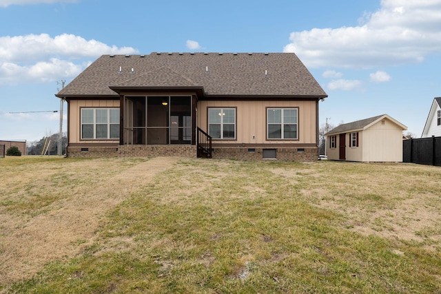 back of house with an outbuilding, a lawn, and a sunroom