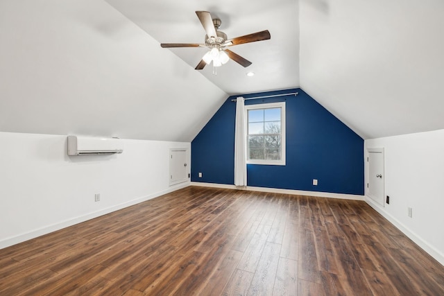 additional living space featuring lofted ceiling, a wall mounted air conditioner, dark hardwood / wood-style floors, and ceiling fan