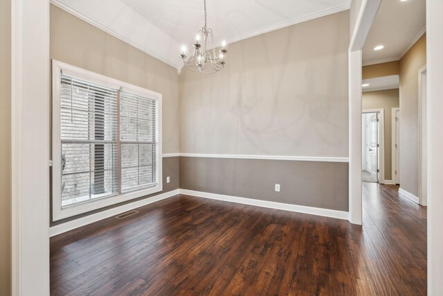 empty room featuring ornamental molding, dark hardwood / wood-style floors, and a chandelier