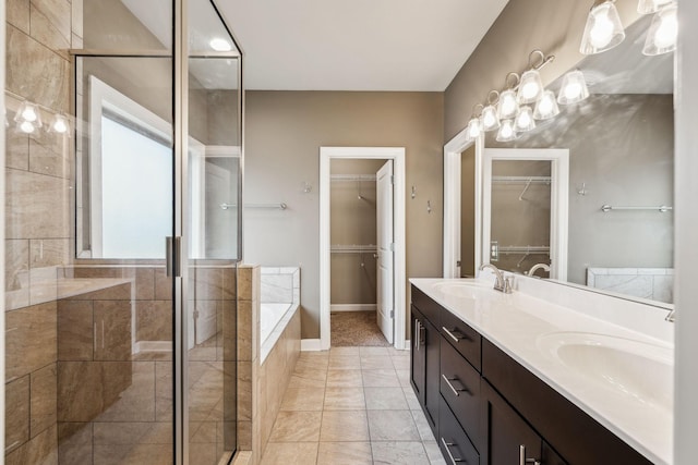 bathroom featuring plus walk in shower, vanity, and tile patterned floors