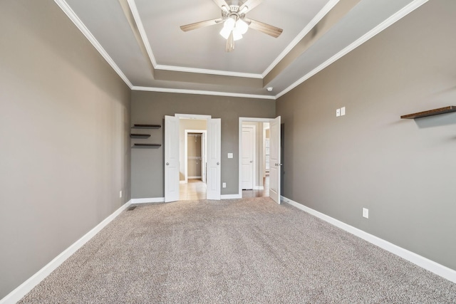 unfurnished bedroom featuring crown molding, a raised ceiling, ceiling fan, and carpet flooring