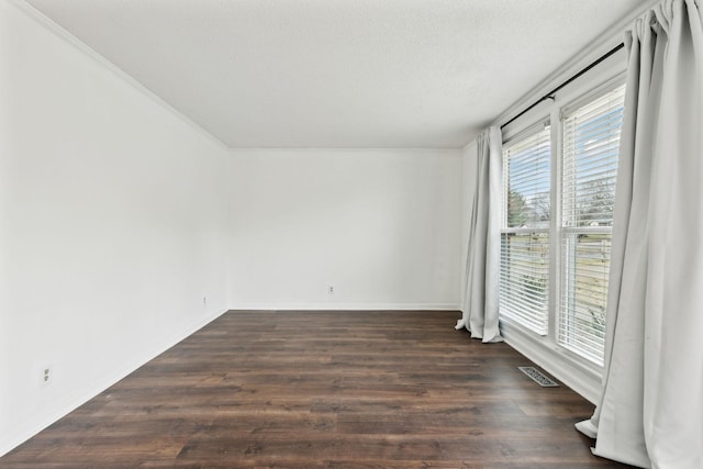 spare room with dark wood-type flooring and a textured ceiling