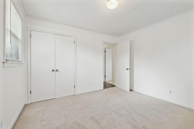 unfurnished bedroom featuring ornamental molding, light carpet, and a textured ceiling