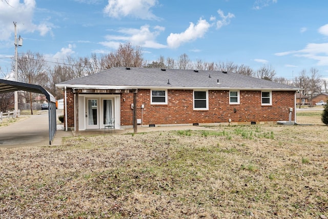 back of house featuring a carport and a lawn