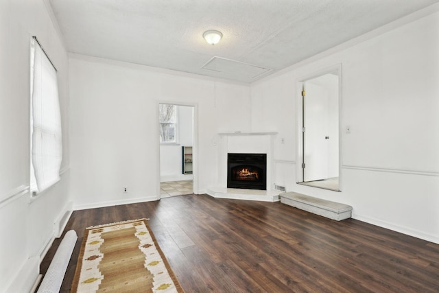 unfurnished living room featuring dark hardwood / wood-style floors and a textured ceiling