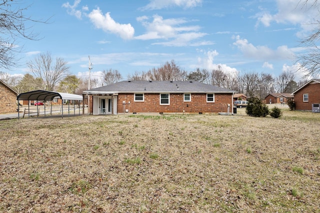 back of house with a carport and a yard