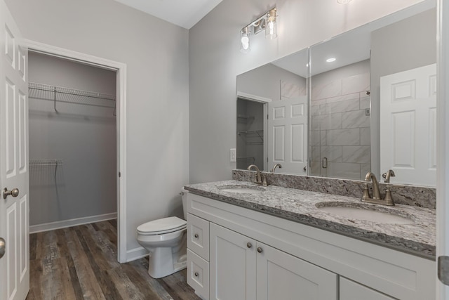 bathroom with vanity, hardwood / wood-style floors, a shower with door, and toilet