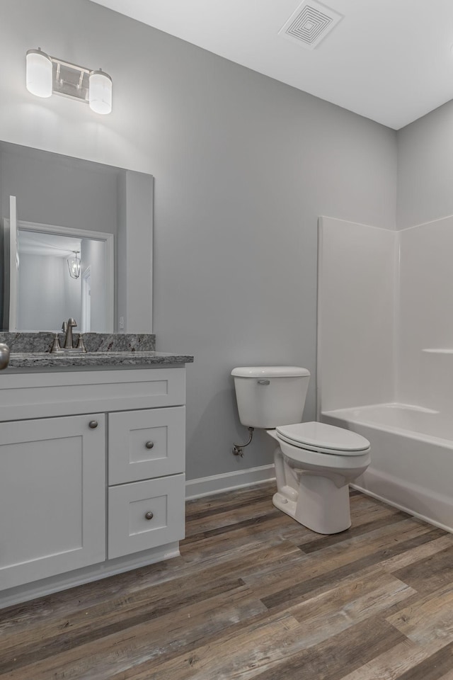 full bathroom featuring shower / tub combination, vanity, wood-type flooring, and toilet